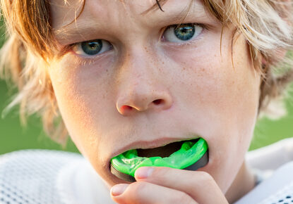 teenage boy putting in mouthguard